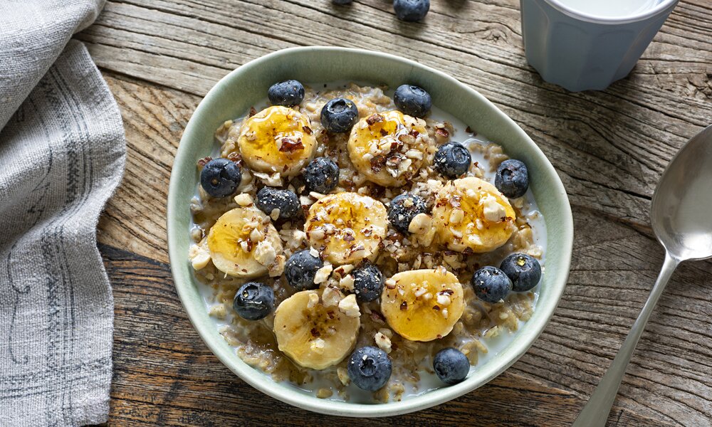 Eine Schüssel voller Porridge, belegt mit Bananenscheiben. | © Getty Images / BURCU ATALAY TANKUT