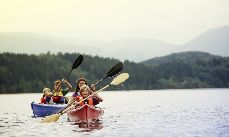 Familie paddelt mit dem Kayak durch einen See | ©  Getty Images / Ted Levine