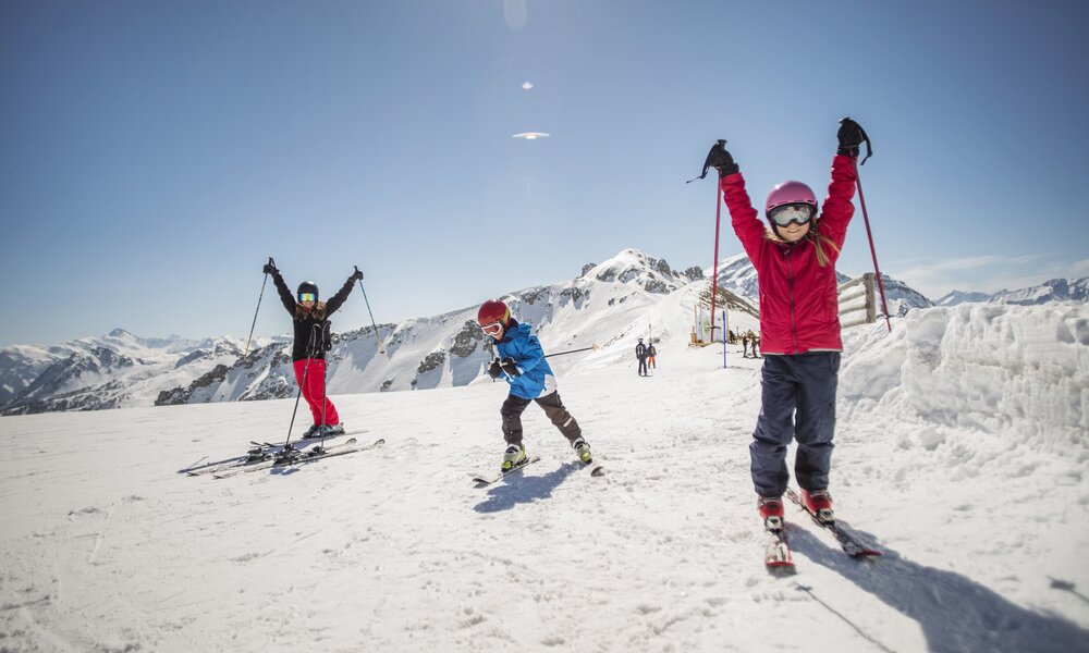 Kinder und Eltern jubeln beim Skifahren | ©  Getty Images / Maskot