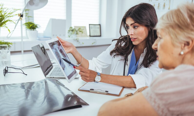 Ärztin erklärt Patentin die Ergebnisse auf dem Röntgenbild. | © Getty Images / dragana991