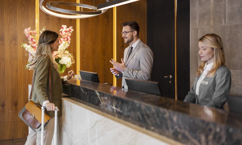 Frau am Hotel-Checkin | ©  Getty Images / PixelsEffect