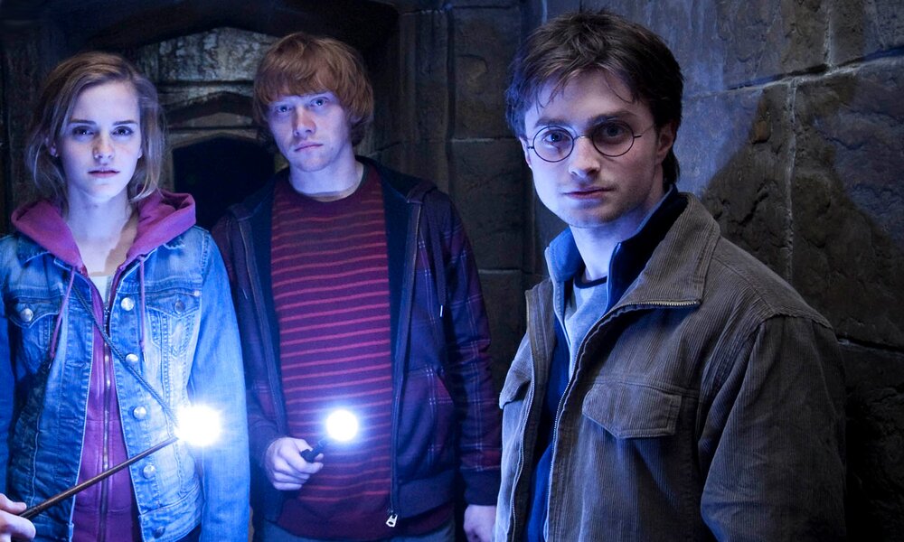 Emma Watson, Rubert Grint und Daniel Radcliffe stehen in einer Szene aus dem Kinofilm "Harry Potter und die Heiligtümer des Todes - Teil 1" in einem  gemauerten dunklen Gang, den sie nur vom Licht erhellt wird, dass die Zauberstäbe abgeben. | © ddp images