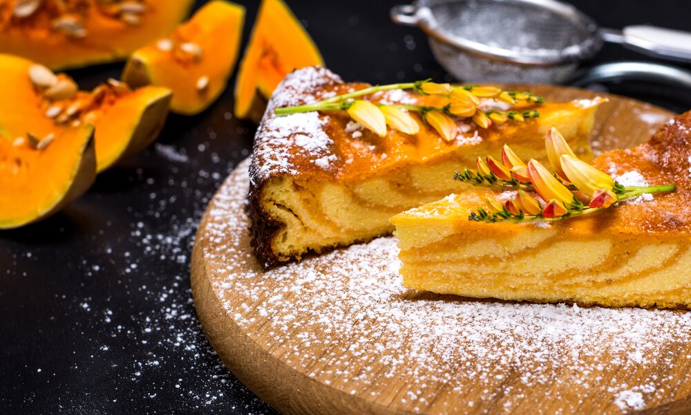 Kürbiskuchen-Stücke angerichtet auf einem dunklen Teller | © Getty Images / nndanko