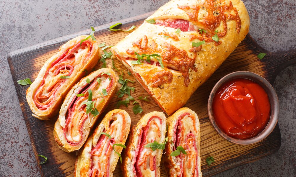Aufgeschnittener herzhafter Strudel mit Schinken. | © Getty Images / ALLEKO