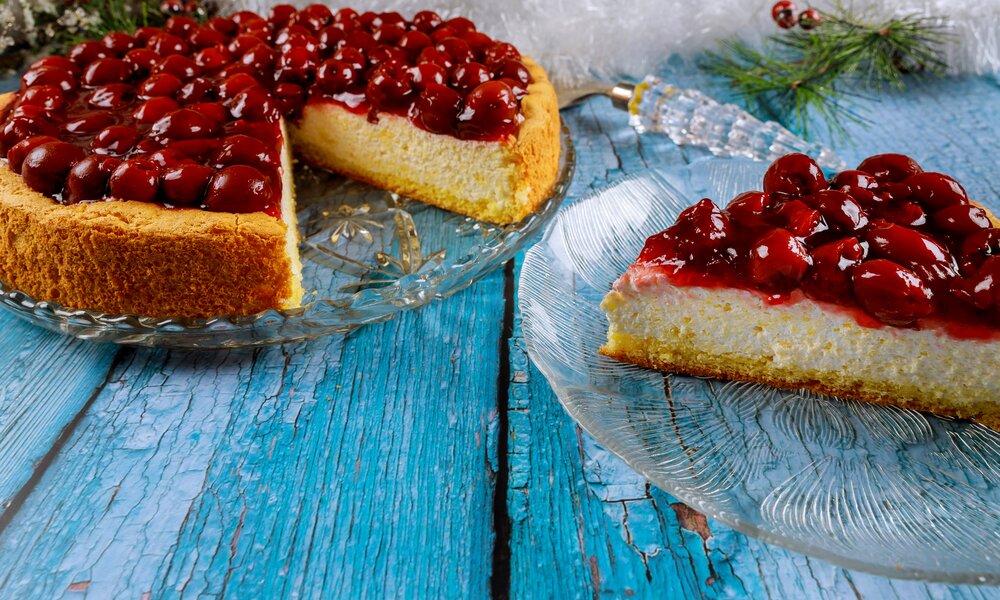 Angeschnittener Kirschkuchen auf einem alten Holzuntergrund in Blau. | © Getty Images / 500