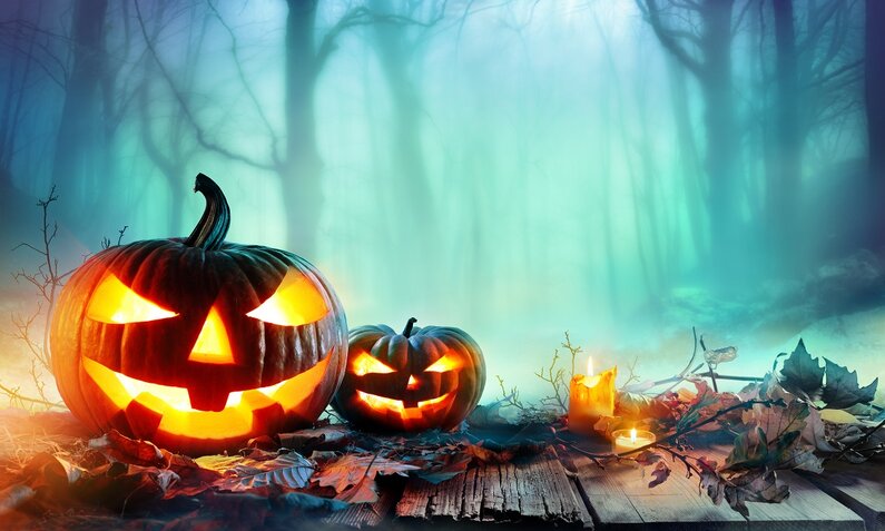 Leuchtende Kürbisse mit bedrohlichen Grimassen vor Halloween-Hintergrund | © © shutterstock / Romolo Tavani