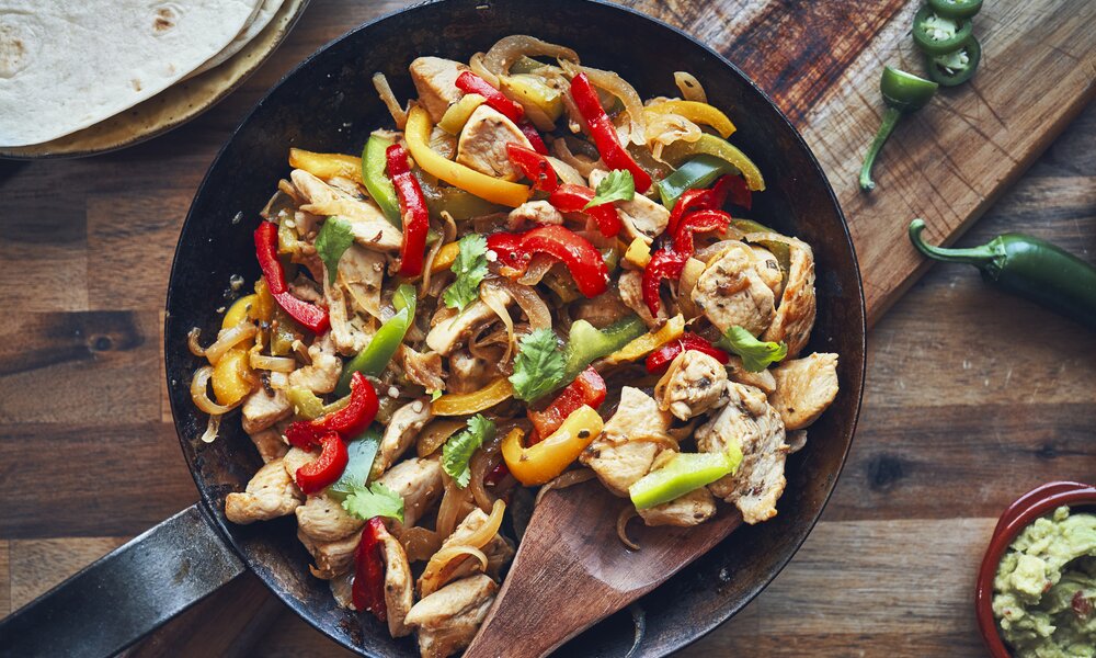 Paprika-Streifen und Hähnchen, knusprig angebraten in einer Pfanne angerichtet. | © Getty Images / GMVozd