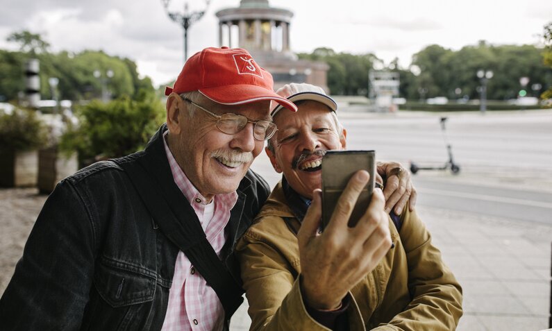 Zwei Rentner schauen aufs Handy und lachen | ©  Getty Images / Willie B. Thomas