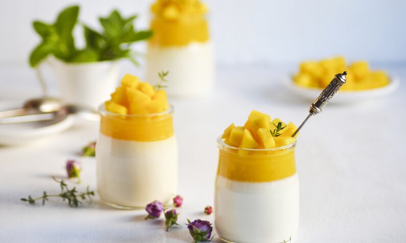 Gelbe Moussee in Dessertgläsern garniert mit Minze. | © Getty Images / Vasylyna Maksymovych