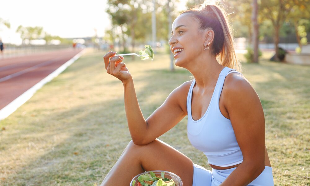 Frau in Sportkleidung ist Salat | © Getty Images / ozgurcankaya