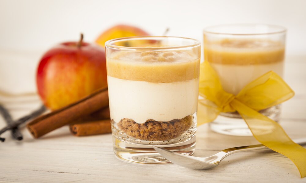 In zwei Dessertgläsern angerichtete Apfelkompott mit Vanillesauce | © Getty Images / eyewave