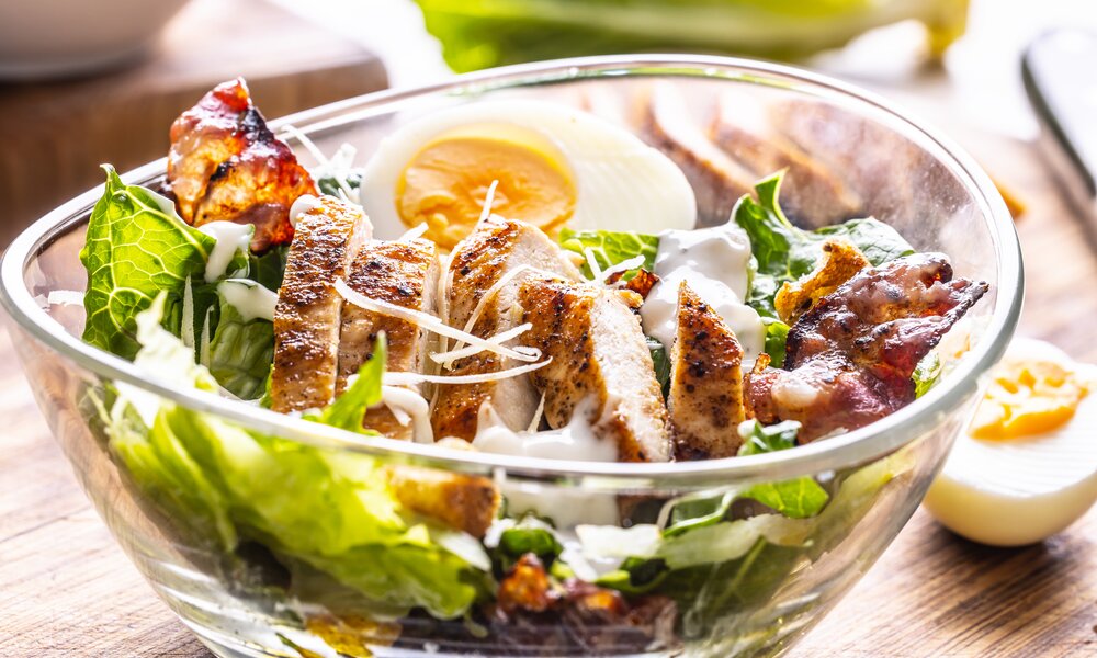Angerichteter Salat mit Hähnchen in einer Glasschüssel. | © Getty Images / SimpleImages