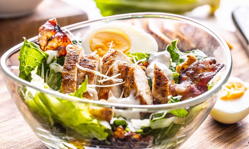 Angerichteter Salat mit Hähnchen in einer Glasschüssel. | © Getty Images / SimpleImages