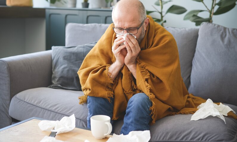 Mann ist krank und putzt sich die Nase | ©  Getty Images / elenaleonova