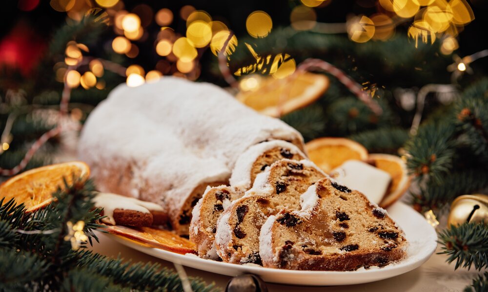 Christstollen in Nahaufnahme, angeschnitten in weihnachtlicher Atmosphäre. | © Getty Images / Nata Serenko