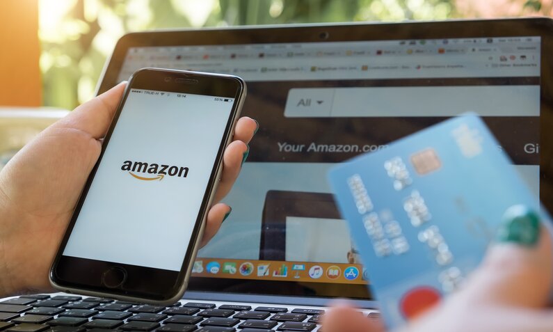 Amazon auf Handy und am Laptop und Kreditkarte | ©  Shutterstock / Worawee Meepian
