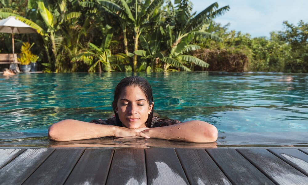 Frau relaxed am Pool in Bali | ©  Getty Images / Vera Vita