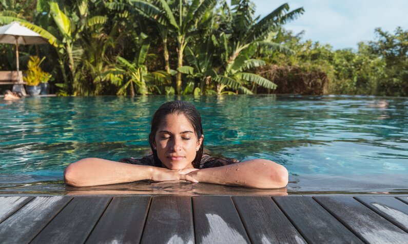 Frau relaxed am Pool in Bali | ©  Getty Images / Vera Vita