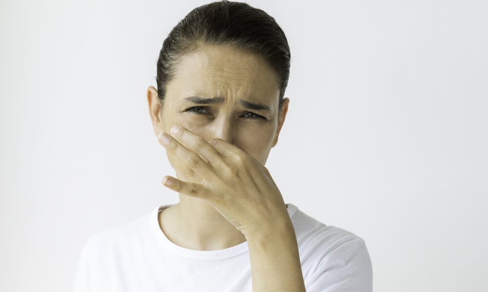 Frau hält sich die Nase zu  | ©  Getty Images / simarik