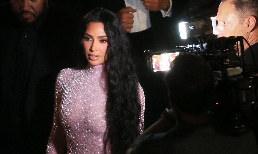 Kim Kardashian im silbernen Abendkleid bei Nacht draußen im Licht von Kameras bei einem Event | © Getty Images/MEGA