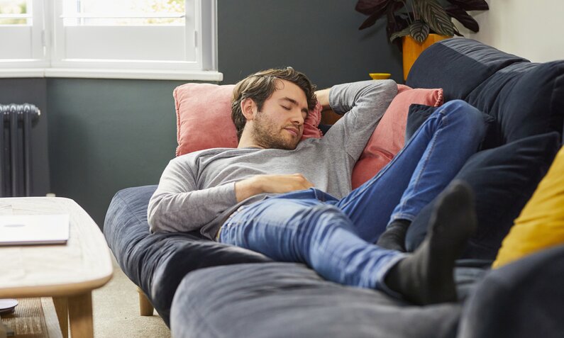 Mann macht Mittagschlaf auf Couch | ©  Getty Images / Tara Moore