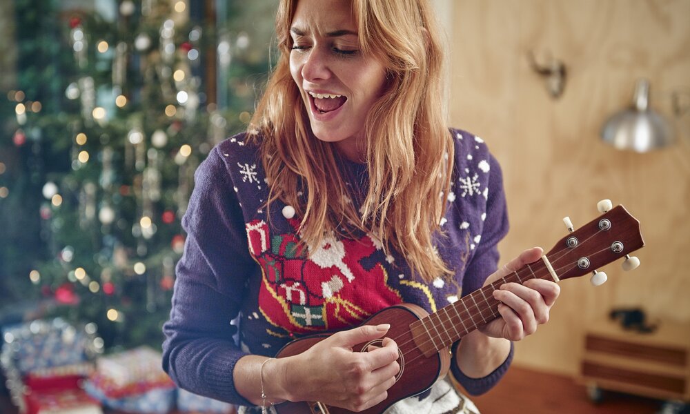 Frau sing mit Ukulele an Weihnachten | ©  Getty Images / Westend61
