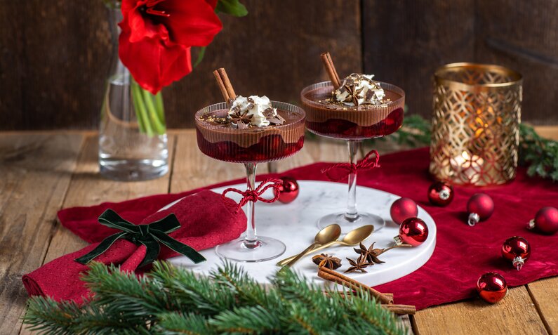 Schokoladencreme mit Kirschen in weihnachtlicher Umgebung. | © Getty Images / MelanieMaya