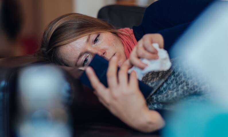 Frau krank am Handy | ©  Getty Images / Guido Mieth