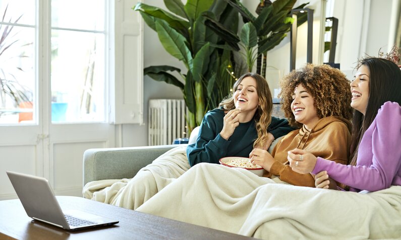 Drei Freundinnen auf einer Couch | ©  Getty Images / Morsa Images