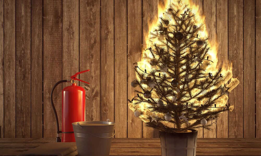 Brennender Weihnachtsbaum mit Feuerlöscher | ©  Getty Images / 2Mmedia