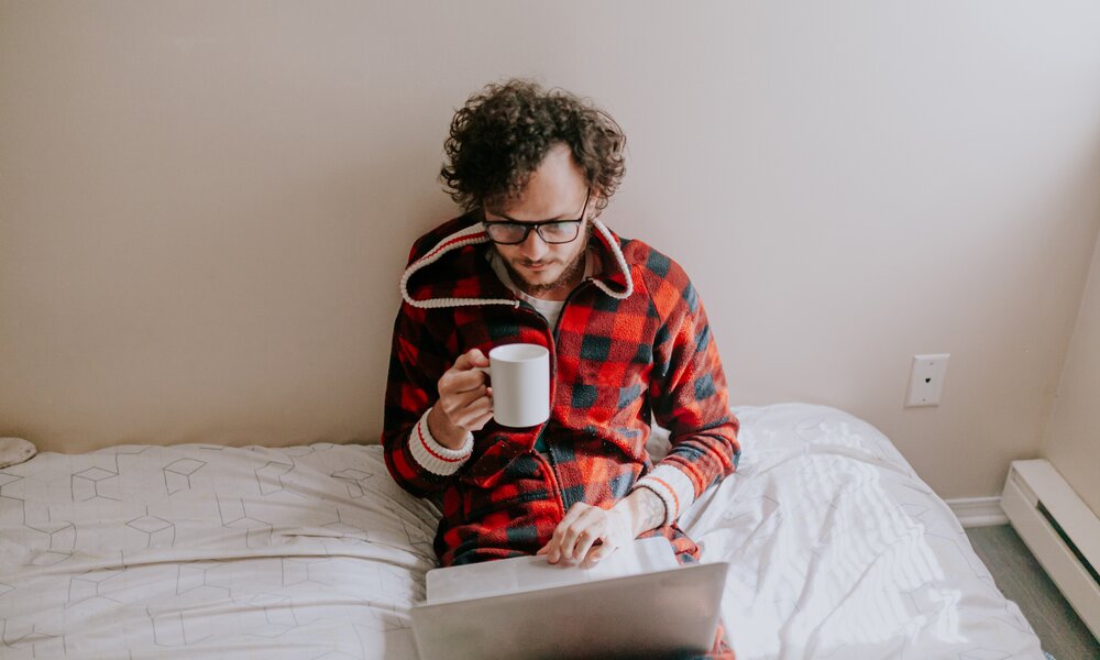 Mann sitzt im Pyjama vor dem Laptop | ©  Getty Images / Marcia Fernandes / 500px