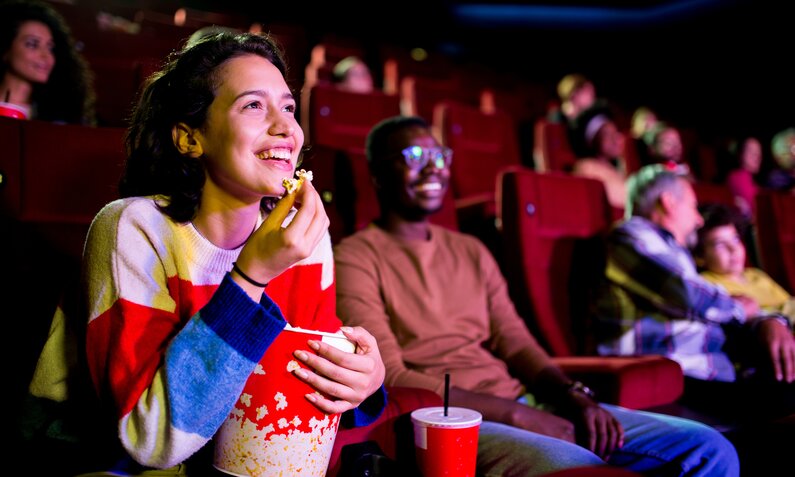 Frau isst Popcorn im Kino | ©  Getty Images / RgStudio