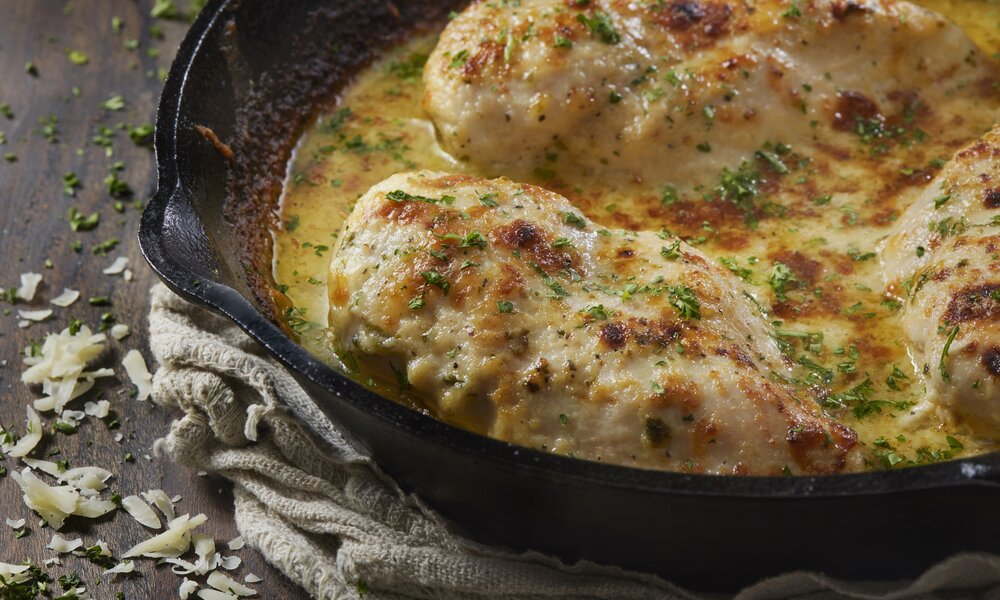 Hähnchen in Sahnesauce in gusseiserner Pfanne. | © Getty Images / 	LauriPatterson