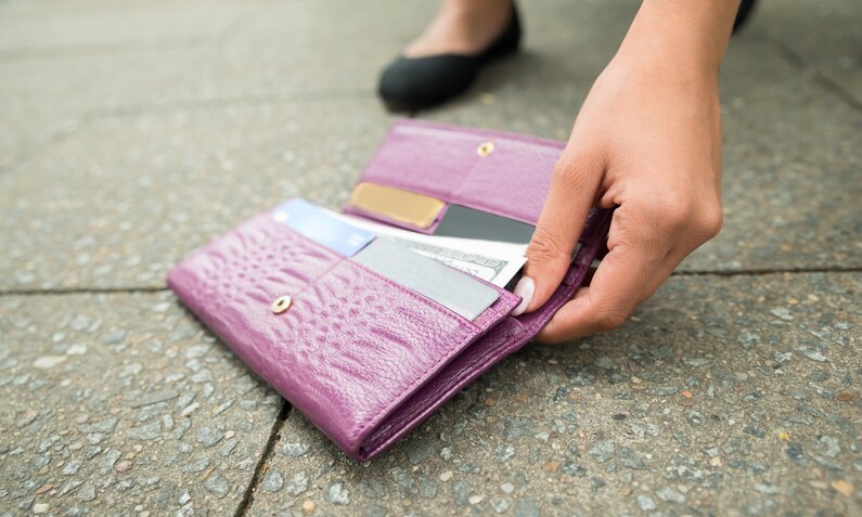 Frau findet Portemonnaie auf Gehweg | ©  Shuttertsock / Andrey_Popov