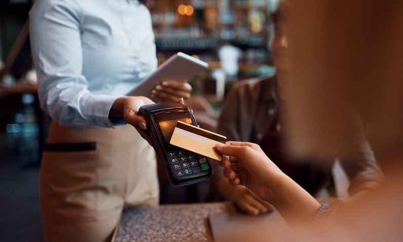 Mann bezahlt im Restaurant mit Karte | ©  Shutterstock / Drazen Zigic
