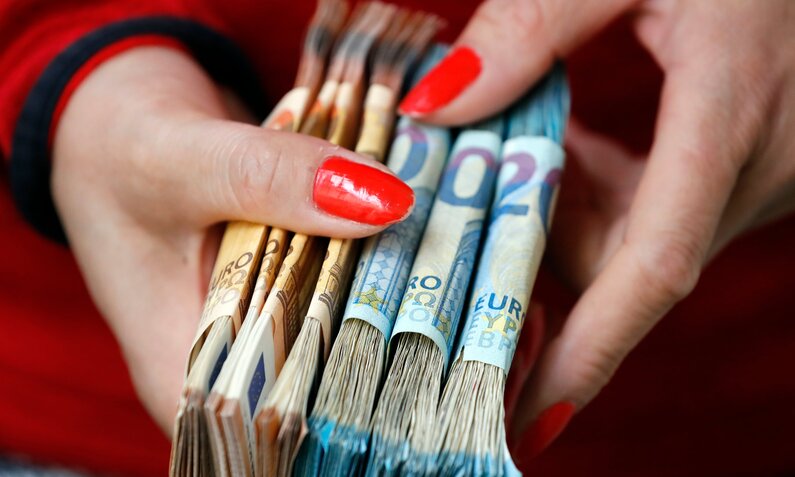 Frau mit gebündelten Euroscheinen | ©  Shutterstock/ godongphoto