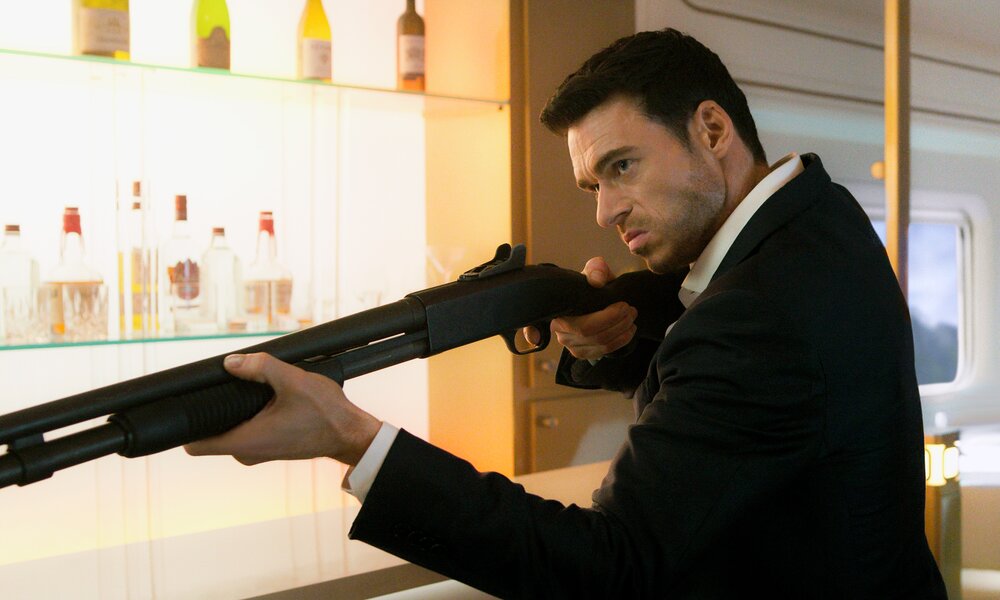 Richard Madden als Geheimagent mit Gewehr im Anschlag steht in einem hochmodernen Zug in einer Szene aus der Prime Video Serie "Citadel" | © Amauon Studios