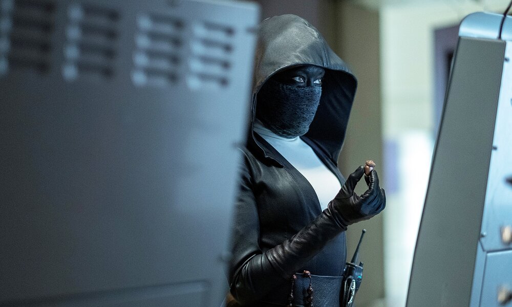 Regina King als Detective Angela Abar steht in Nonnen-Uniform mit maskiertem Gesicht in einem düsteren Innenraum in einer Szene der HBO-Serie "Watchmen". | © © 2019 Home Box Office, Inc. All rights reserved. HBO® and related channels and service marks are the property of Home Box Office, Inc.