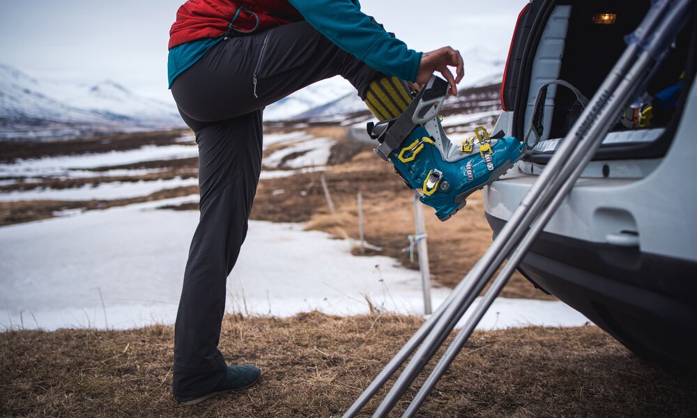 Mann zieht Skischuhe am Auto an | ©  Getty Images / avan Images