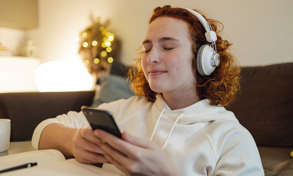 Eine Frau hört einen Podcast | © Getty Images / E+ /blackCAT