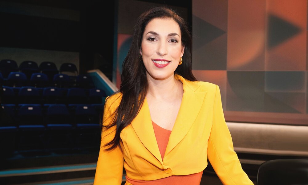 Foto von Unternehmerin Tijen Onaran in einem orangefarbenen Anzug im TV-Studio der Sendung "Hart aber Fair" | © Imago Images/T. Bartilla/Future Image 