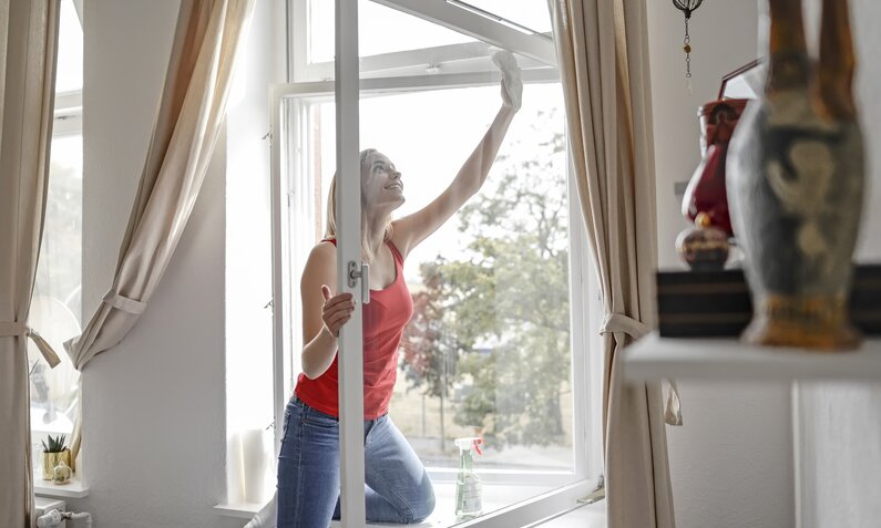 Frau putzt Fenster | ©  Getty Images/ Westend61