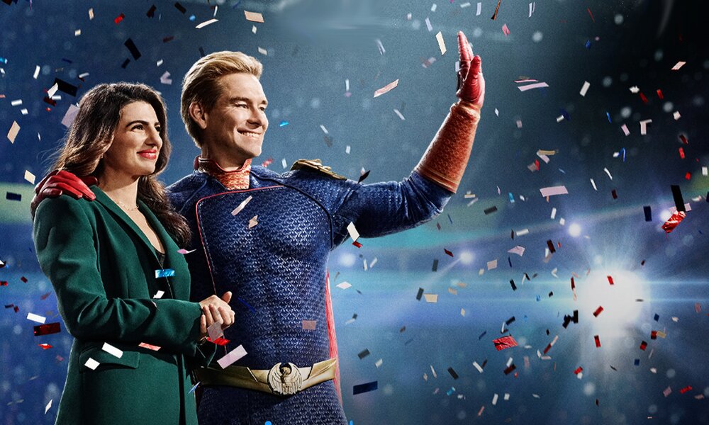 Claudia Doumit als Victoria Neumann und Anthony Starr als Homelander stehen in Superhero-Kostümen vor blauem Hintergrund im Konfettiregen auf der Key Art zur Prime Video Serie "The Boys" Staffel 4. | © Amazon Studios/Prime Video