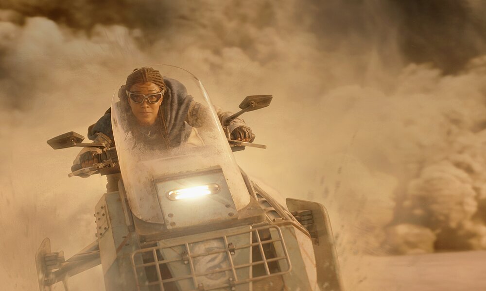 Sonequa Martin-Geen  rast auf einem futuristischen Gefährt vor gigantischen Staubwolken davon in einer Szene aus der 5. Staffel Paramount Serie "Star Trek: Discovery"  | © 2022 CPS Studios Inc. All rights reserved/Paramount+