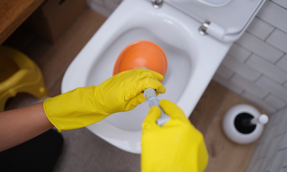 Verstopftes Klo wird mit Pömpel beseitigt | ©  Getty Images/ Ivan-balvan