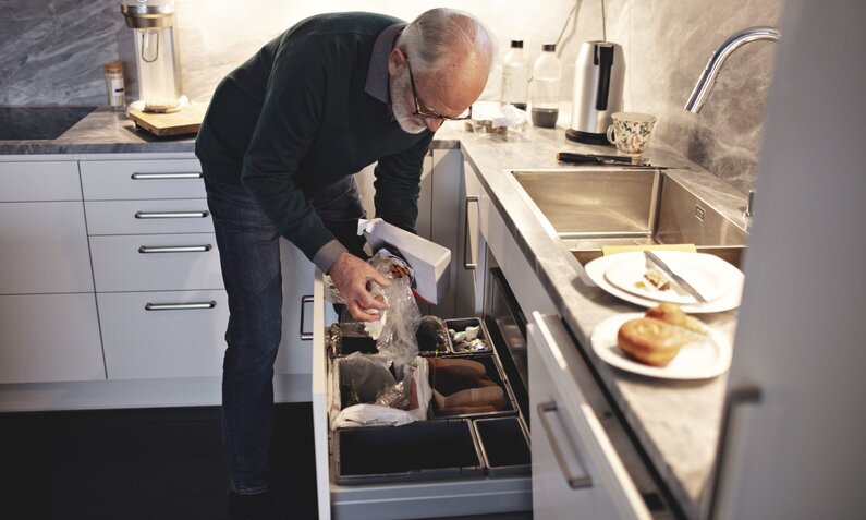 Mann wirft etwas in den Hausmüll | ©  Getty Images/ Maskot