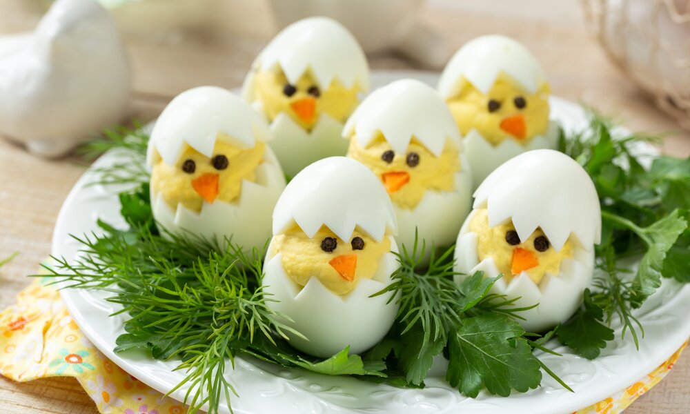 Niedliche Eier, gefüllt mit gelber Creme, aussehend wie kleine Küken.  | © Adobe Stock / anna_shepulova