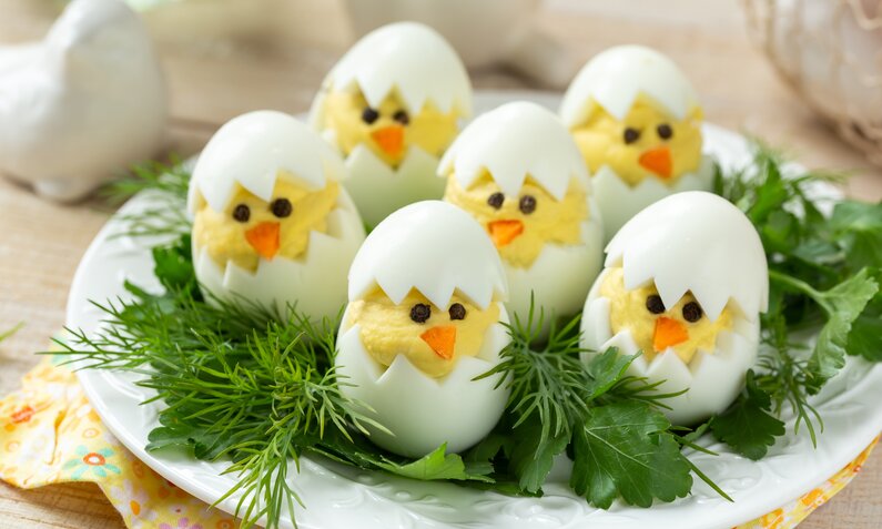 Niedliche Eier, gefüllt mit gelber Creme, aussehend wie kleine Küken.  | © Adobe Stock / anna_shepulova