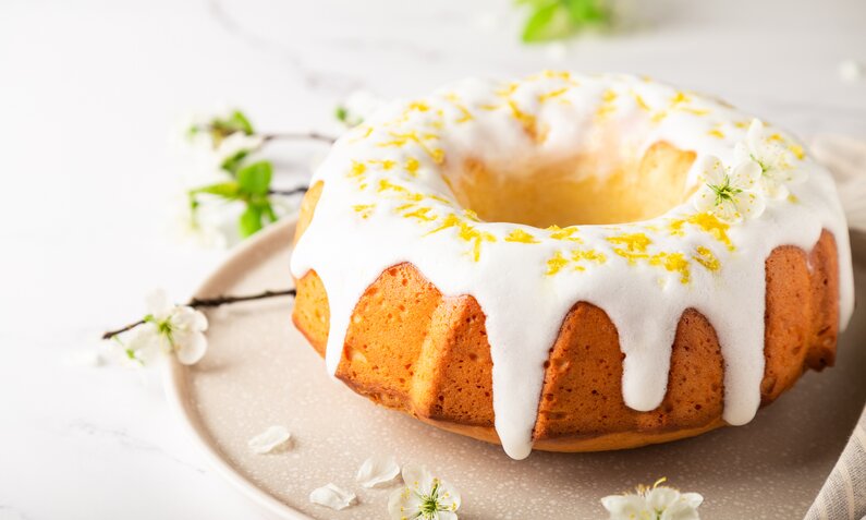 Kuchen in Gugelhupf-Form, begossen mit Zuckerguss in Frühlings-Atmosphäre. | © Getty Images / Anaiz777