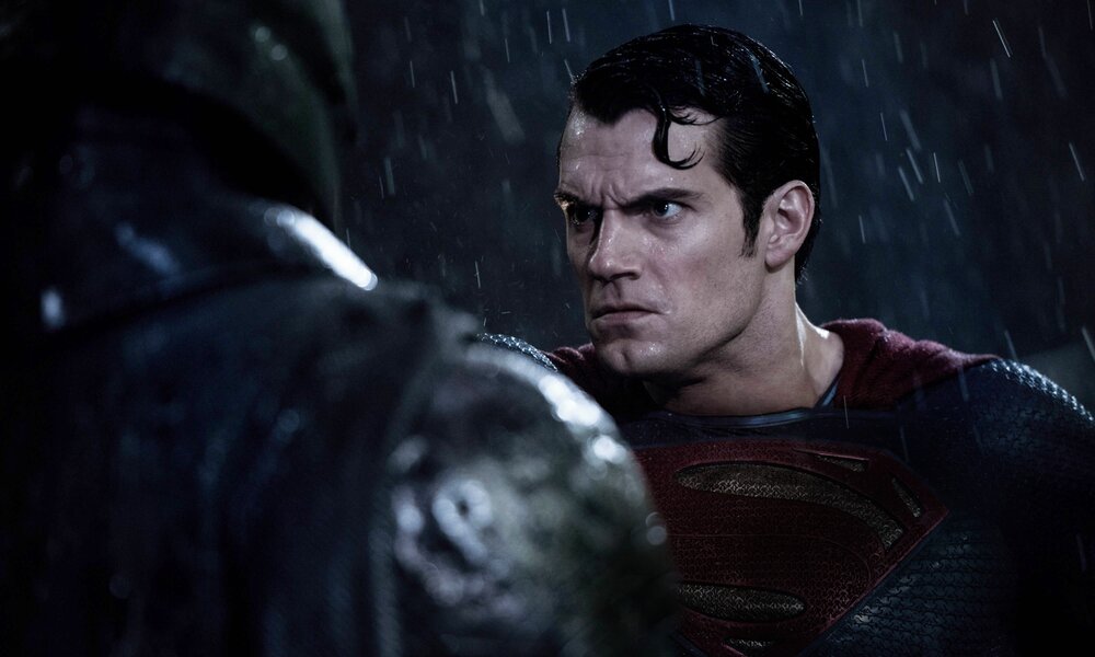 Nahaufnahme von Henry Cavills zornigem Gesicht, der Batman im Regen bei Nacht gegenübersteht in einer Szene aus dem Kinofilm "Batman V Superman: Dawn Of Justice" | © Imago/Cinema Publishers Collection
